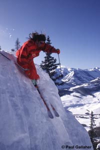 Skier coming over cornice