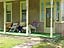 These folks enjoy an afternoon breeze sitting on their porch, watching everyone go by on Elk Ave, as the sun begins to head west.